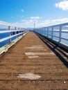 A wood pier leading into the ocean with copy space. An old empty platform or dock terrace on a lake with blue water Royalty Free Stock Photo