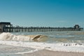 Wood pier stretching into gulf of mexico and tropical beach, on a clear, windy day Royalty Free Stock Photo