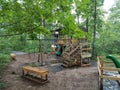 Wood play structure with benches, swings, and dinosaur
