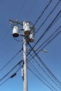 Electric urban wooden poles / post with cables and three cylinder transformers.