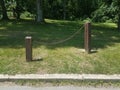 Wood posts connected with a chain in the grass