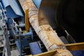 Wood processing at a sawmill. Preparation of a log for the production of plywood and veneer, sawing and cleaning of blanks in a Royalty Free Stock Photo