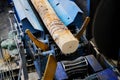 Wood processing at a sawmill. Preparation of a log for the production of plywood and veneer, sawing and cleaning of blanks in a Royalty Free Stock Photo