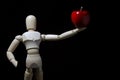 Wood robot and mini apple in action . Royalty Free Stock Photo