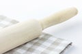 Wood Rolling Pin on White and Beige Chequered Cotton Kitchen Towel. Tabletop. Baking Essentials. Holidays Christmas Easter.