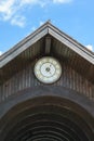 Wood roof arcade with old roman golden numbers clock showing 13:25