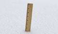 Wood ruler pushed into the snow measuring five inches of snowfall