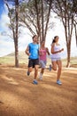 Wood, running and group for outdoor on forest trail, environment and nature in summer for exercise. Diverse, friends and Royalty Free Stock Photo