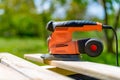 Wood sanding in the garden. DIY home improvement, restoration, carpentry concept. Close up shot of an electric sander. Royalty Free Stock Photo