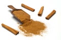 Wood scoop with cinnamon powder and cinnamon sticks isolated on white background Royalty Free Stock Photo