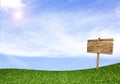 Wood sign on green field under blue sky Royalty Free Stock Photo