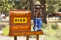 Wood sign showing fire risk level with a bear caricature wearing a hat in Mammoth Lakes