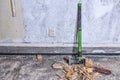 Wood splitting maul stands at concrete wall on demolished room floor, close up view