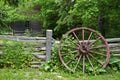 Wood spoke wagon wheel left on the wooden fence on a farmhouse Royalty Free Stock Photo