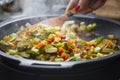 Wood spoon mixing veggies on a pan Royalty Free Stock Photo