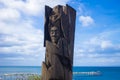 Wood Statue of an indigenous with the see behind in Punta Arenas, Chile centred