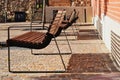 brown wood park benches on metal frame in a row. urban setting. cobblestone street pavement. small trees with cast iron grate. Royalty Free Stock Photo