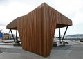 Modern wood North Kumutoto Pavilion with strips on folded plates and steel posts on waterfront plaza, Wellington, New Zealand Royalty Free Stock Photo