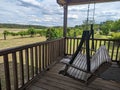 Wood swing in porch with grapevines