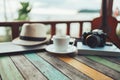 Wood table and Coffee, straw hat, camera blur background at resort and beach background Royalty Free Stock Photo