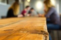 wood table edge, soft focus customers using laptops behind Royalty Free Stock Photo