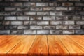 Wood table in front of brick wall blur background. Royalty Free Stock Photo
