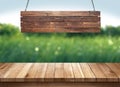 Wood table with hanging wooden sign on green nature blurred background Royalty Free Stock Photo