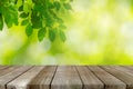 Wood table top and Abstract blur green leaves background Royalty Free Stock Photo