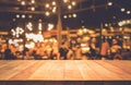 Wood table top Bar with blur light bokeh in dark night cafe Royalty Free Stock Photo