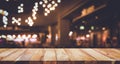 Wood table top Bar with blur light bokeh in dark night cafe Royalty Free Stock Photo