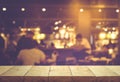 Wood table top (Bar) with blur people siting night cafe,restaurant background .Lifestyle and celebration concepts Royalty Free Stock Photo