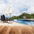 Wood table top on Beach chair in outdoor with swimming pool and Royalty Free Stock Photo