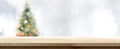 Wood table top on blur Christmas tree banner background