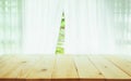 Wood table top on blur of curtain with window view green from tr Royalty Free Stock Photo