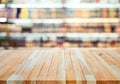 Wood table top on blur of drinking product shelf background in  supermarket or grocery background Royalty Free Stock Photo