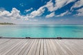 Wooden floor with blurred sea and coconut tree under blue sky background with copy space Royalty Free Stock Photo