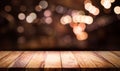 Wood table top with blur light bokeh in dark night cafe
