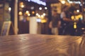 Wood table top with blur of lighting in night cafe restaurant community Royalty Free Stock Photo