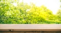Wood table top with blur of orange garden in the morning. Royalty Free Stock Photo