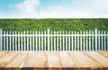 Wood table top on blur of white fence and garden background. Royalty Free Stock Photo