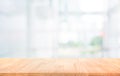 Wood table top on blur white glass wall background form office