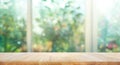 Wood table top on blur of window with garden flower background Royalty Free Stock Photo