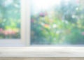 Wood table top on blur of window with garden flower background Royalty Free Stock Photo