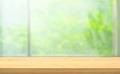 Wood table top on blur of window with garden flower background in morning Royalty Free Stock Photo