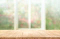 Wood table top on blur of window with garden flower background Royalty Free Stock Photo