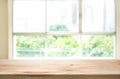 Wood table top on blur of window glass and abstract green garden Royalty Free Stock Photo