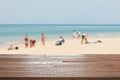 Wood table top on blurred blue sea and white sand beach with some people Royalty Free Stock Photo