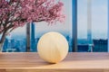 Wood table top and blurred bokeh modern office interior with one wooden sphere ball; 3D Illustration