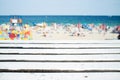 Wood table top with blurred people at the beach Royalty Free Stock Photo