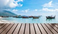 Wood table top on blurred sea group long tail boat